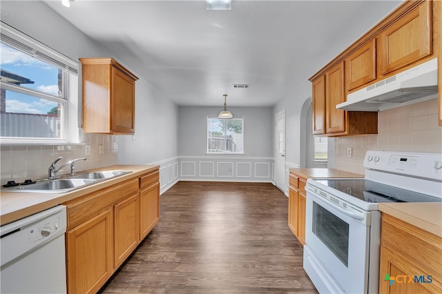 kitchen featuring dark hardwood / wood-style flooring, pendant lighting, decorative backsplash, sink, and white appliances