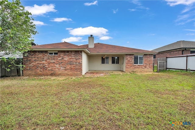 rear view of property with a yard