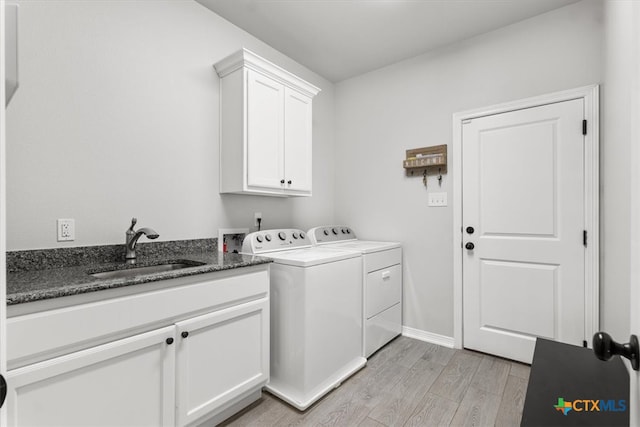 laundry area featuring cabinets, sink, washer and dryer, and light hardwood / wood-style floors