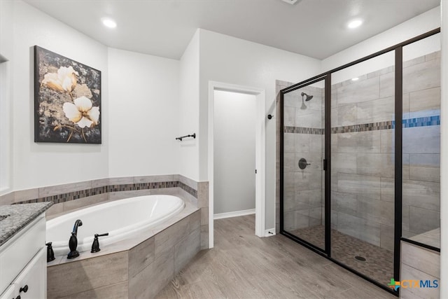 bathroom with vanity, hardwood / wood-style floors, and separate shower and tub