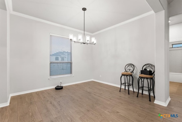 dining area with wood-type flooring, a chandelier, and ornamental molding