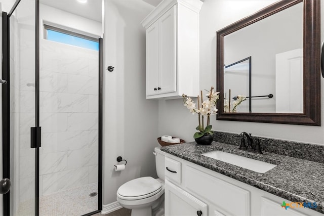 bathroom featuring toilet, vanity, and a shower with shower door