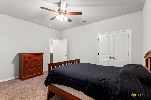 carpeted bedroom with ceiling fan and a closet