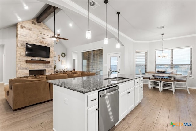 kitchen featuring white cabinetry, light hardwood / wood-style floors, stainless steel dishwasher, and an island with sink