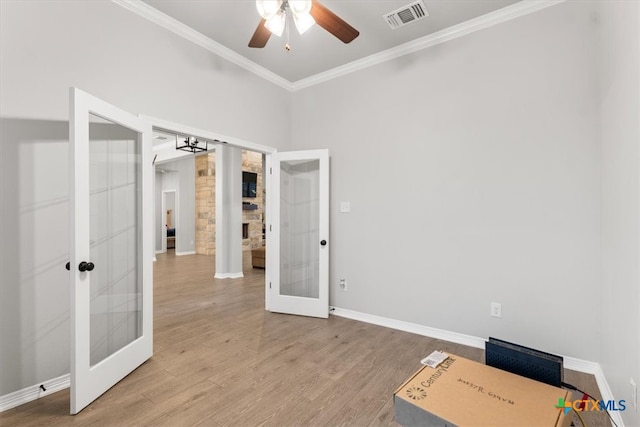 unfurnished office featuring light wood-type flooring, french doors, ceiling fan, and crown molding