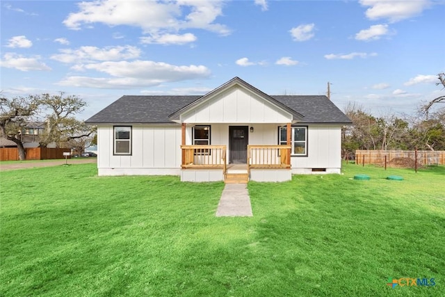 view of front facade with a porch, fence, roof with shingles, a front yard, and crawl space