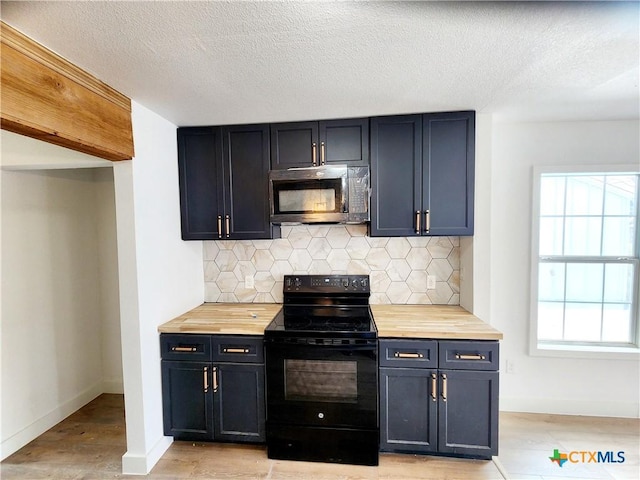 kitchen with stainless steel microwave, black range with electric stovetop, tasteful backsplash, and a wealth of natural light