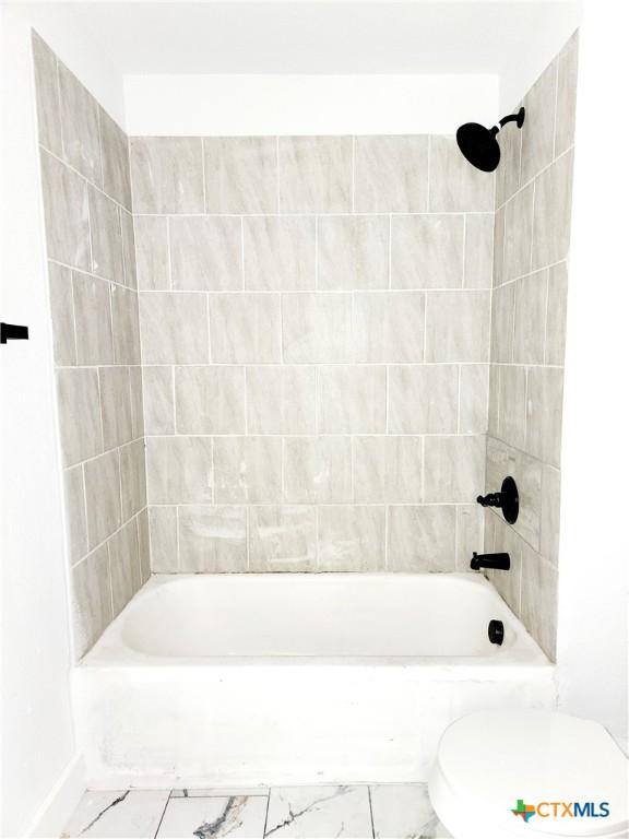 full bath with marble finish floor, toilet, and shower / washtub combination