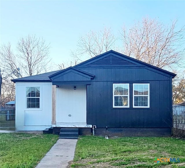 view of front of house with a front lawn and fence