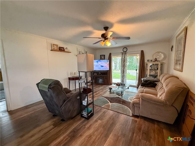 living room featuring dark hardwood / wood-style flooring, ceiling fan, and crown molding