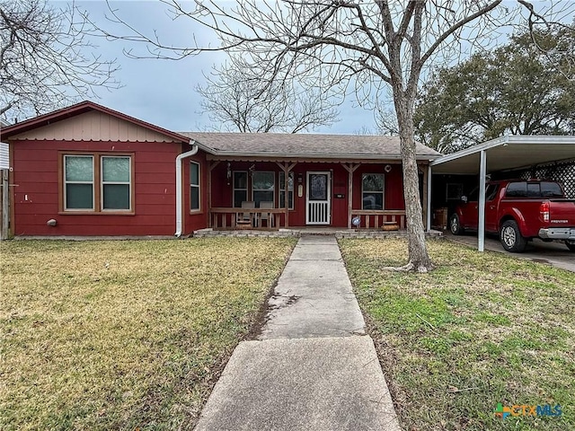 view of front facade featuring a carport, a porch, and a front yard