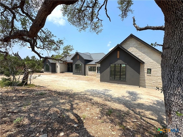 985 Malbec Loop, Canyon Lake, TX 78133 - rear view of property with stone siding, a metal roof, stucco siding, and a standing seam roof