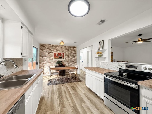 1412 Laurie Dr, Canyon Lake, TX 78133 - kitchen featuring stainless steel appliances, a sink, white cabinets, backsplash, and light wood-type flooring