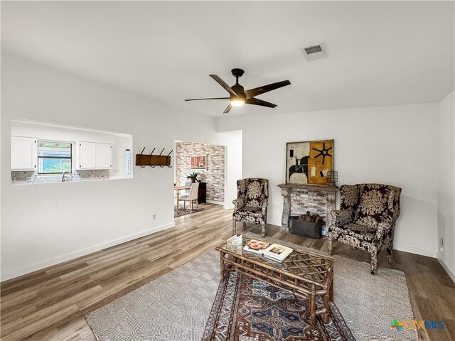 1412 Laurie Dr, Canyon Lake, TX 78133 - sitting room with wood finished floors, ceiling fan, a fireplace, and baseboards