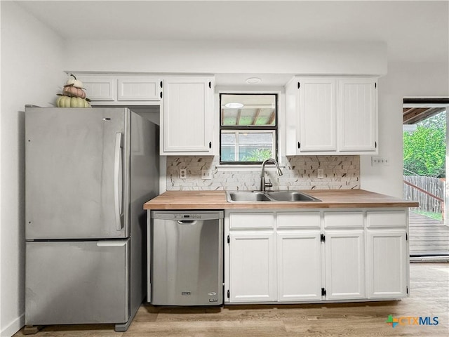 1412 Laurie Dr, Canyon Lake, TX 78133 - kitchen featuring stainless steel appliances, a sink, butcher block countertops, white cabinetry, and tasteful backsplash