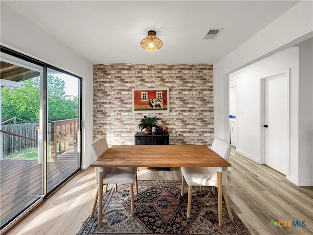1412 Laurie Dr, Canyon Lake, TX 78133 - dining space featuring light wood-style floors, brick wall, baseboards, and a wood stove