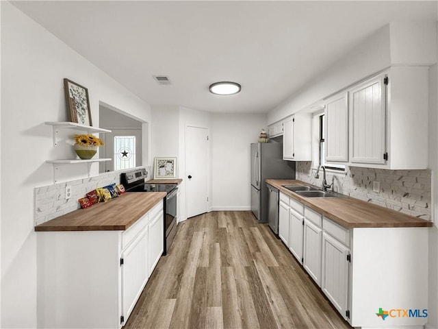 1412 Laurie Dr, Canyon Lake, TX 78133 - kitchen with stainless steel appliances, butcher block countertops, a sink, tasteful backsplash, and light wood-style floors