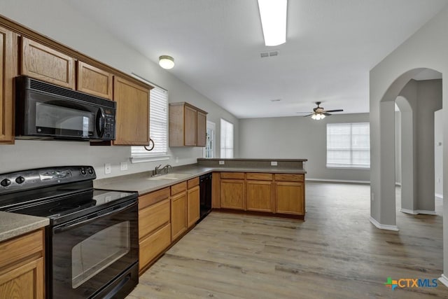 kitchen featuring kitchen peninsula, ceiling fan, sink, black appliances, and light hardwood / wood-style floors