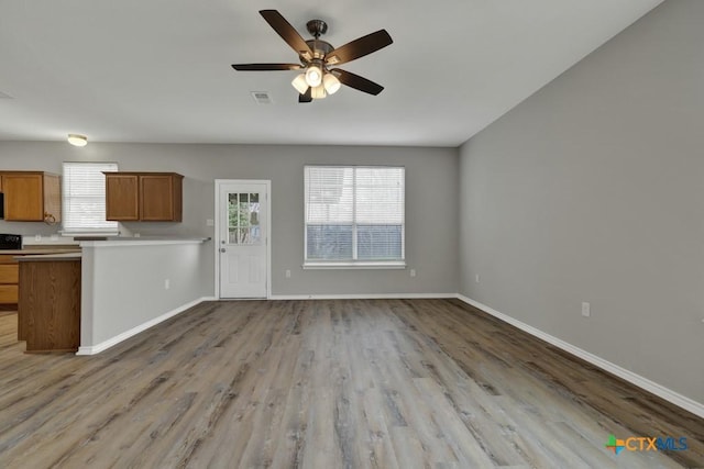 kitchen with kitchen peninsula, ceiling fan, and light wood-type flooring