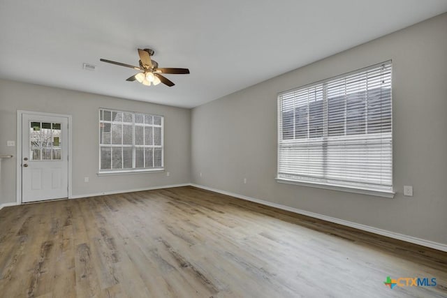 unfurnished room featuring light hardwood / wood-style flooring, ceiling fan, and a healthy amount of sunlight