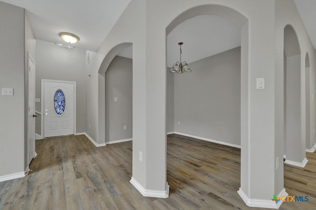 foyer entrance with hardwood / wood-style floors and an inviting chandelier