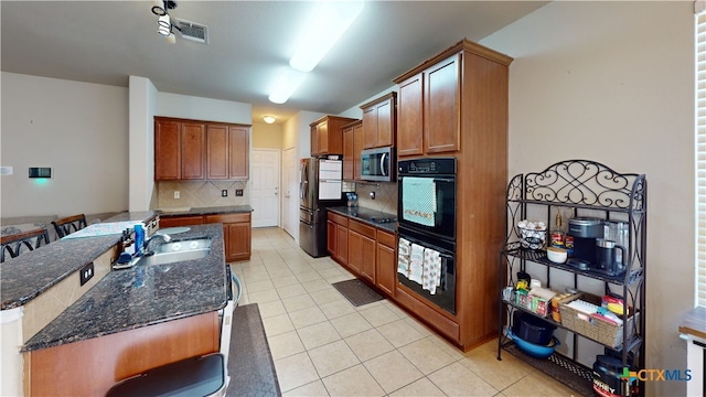 1906 Terry Dr, Copperas Cove, TX 76522 - kitchen with appliances with stainless steel finishes, a sink, decorative backsplash, light tile patterned floors, and brown cabinets