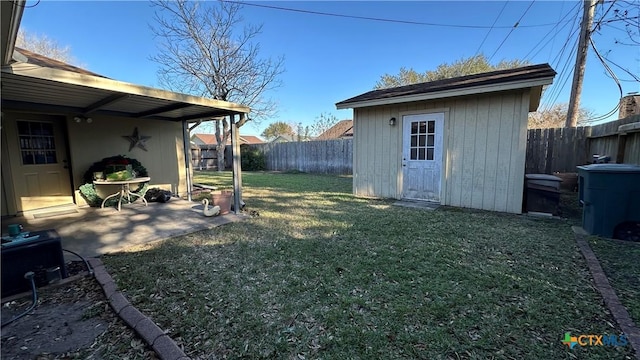 view of yard featuring a patio area, a fenced backyard, an outdoor structure, and a storage unit