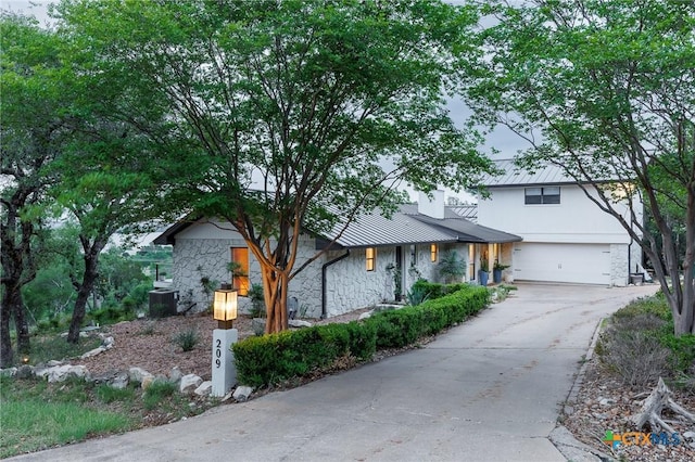 209 Full Moon, Horseshoe Bay, TX 78657 - view of front of house with stone siding, concrete driveway, metal roof, and a garage