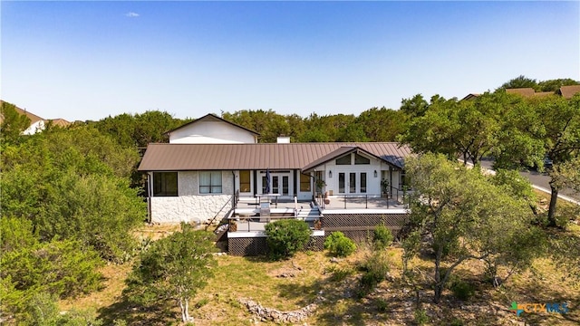 209 Full Moon, Horseshoe Bay, TX 78657 - rear view of house featuring french doors, a wooden deck, stone siding, and metal roof