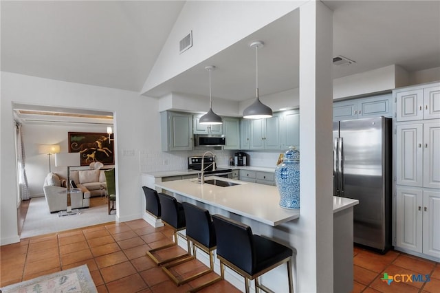 209 Full Moon, Horseshoe Bay, TX 78657 - kitchen with stainless steel appliances, light countertops, a sink, tile patterned flooring, and lofted ceiling