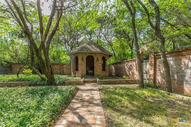 2518 Marlandwood Rd, Temple, TX 76502 - tudor home featuring brick siding, a fenced backyard, and an outbuilding