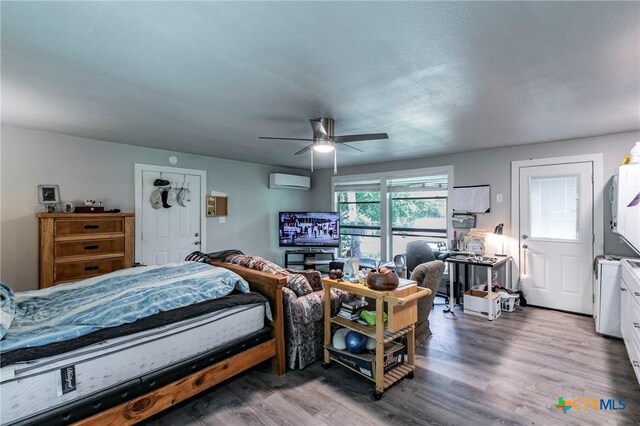 2518 Marlandwood Rd, Temple, TX 76502 - bedroom with a ceiling fan, wood finished floors, and an AC wall unit