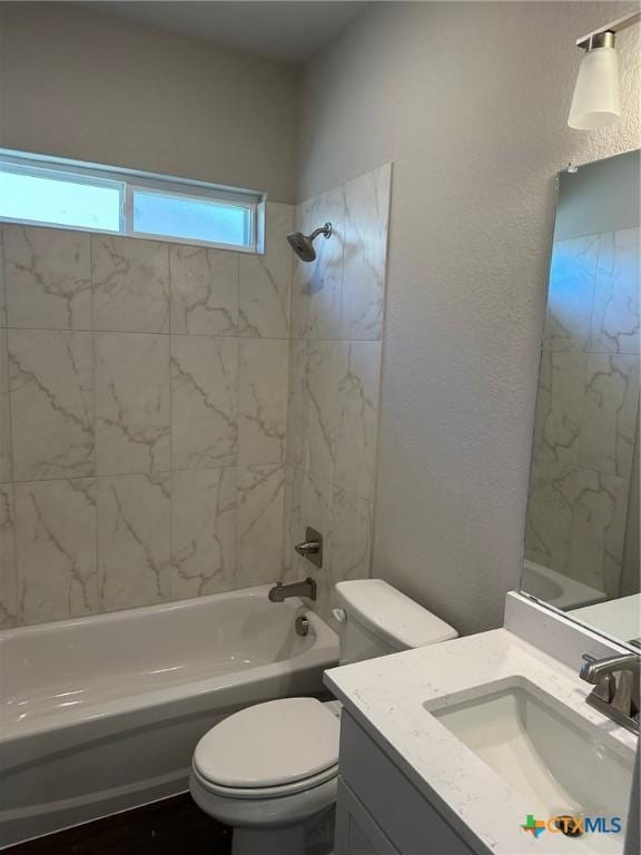 bathroom featuring  shower combination, a textured wall, toilet, and vanity