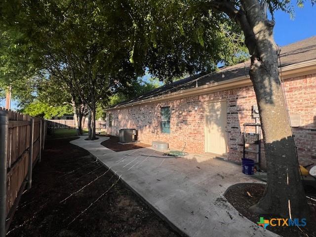 2800 S 3- A St, Waco, TX 76706 - view of side of property featuring cooling unit, brick siding, and a patio area