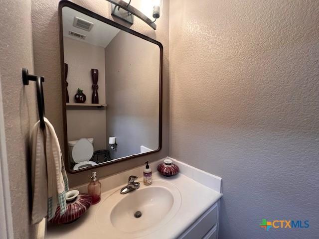 2800 S 3- A St, Waco, TX 76706 - half bathroom with a textured wall, vanity, and toilet