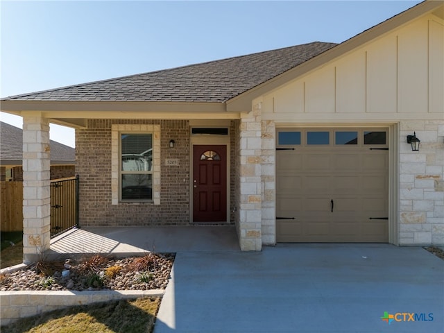 view of front facade featuring brick siding, board and batten siding, concrete driveway, roof with shingles, and an attached garage