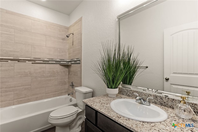 full bathroom with vanity, toilet, a textured wall, and shower / bathtub combination