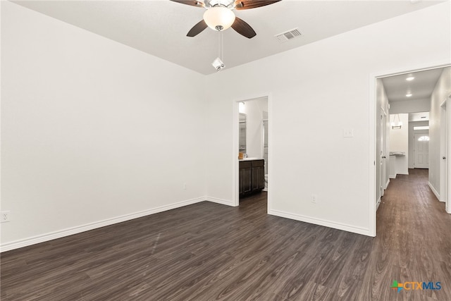 spare room featuring visible vents, ceiling fan, dark wood-type flooring, and baseboards