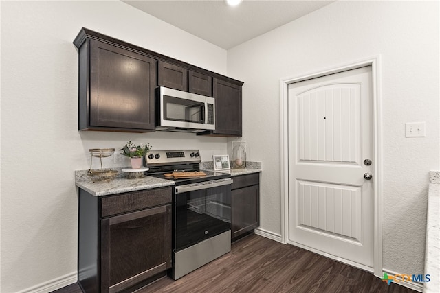 kitchen featuring dark brown cabinets, baseboards, dark wood-style flooring, and stainless steel appliances