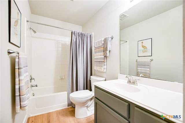 full bathroom featuring hardwood / wood-style floors, shower / bath combo, toilet, and vanity