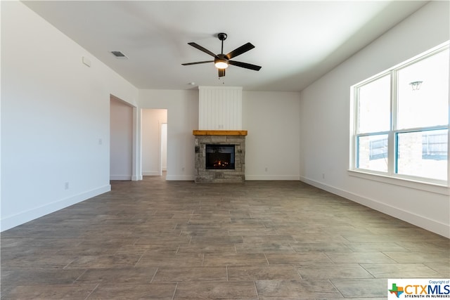 unfurnished living room with a fireplace and ceiling fan