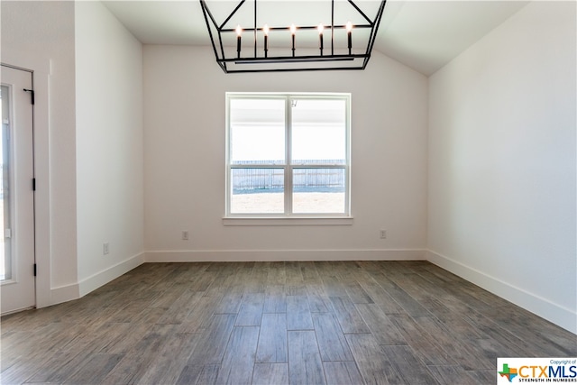 unfurnished room with hardwood / wood-style floors, lofted ceiling, and a chandelier