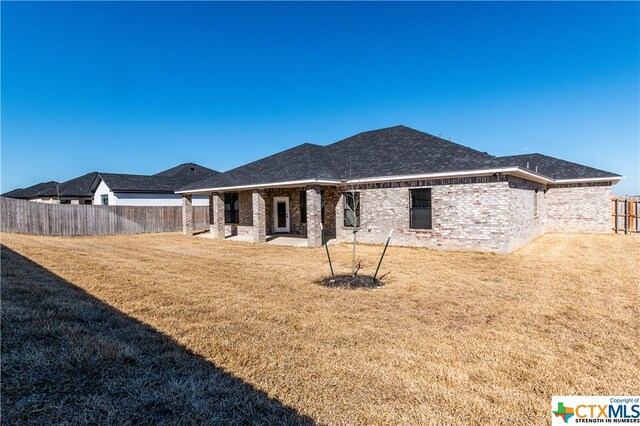 back of house featuring a yard and a patio area