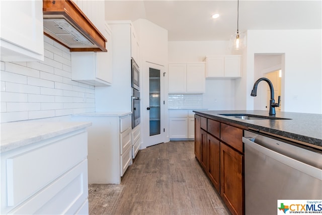 kitchen with stainless steel appliances, custom range hood, white cabinetry, and light wood-type flooring