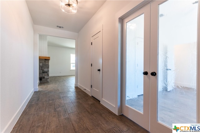 corridor with dark wood-type flooring and french doors