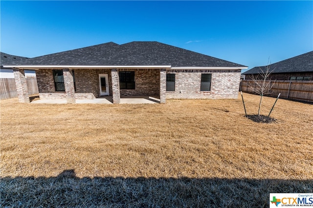 rear view of house with a patio and a yard