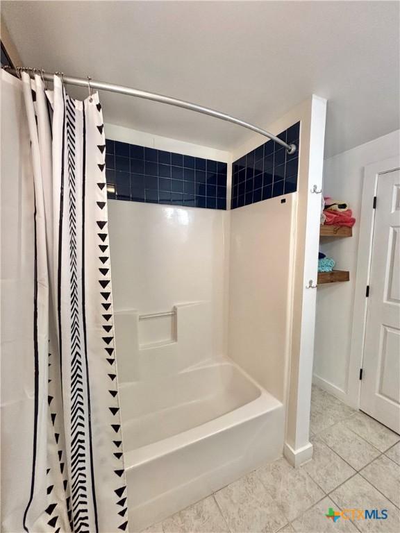 bathroom with tile patterned flooring and shower / tub combo