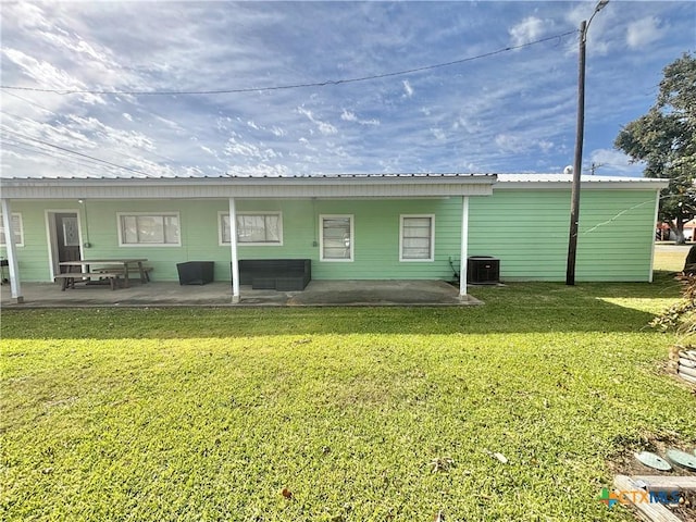 back of house with central AC, a yard, and a patio