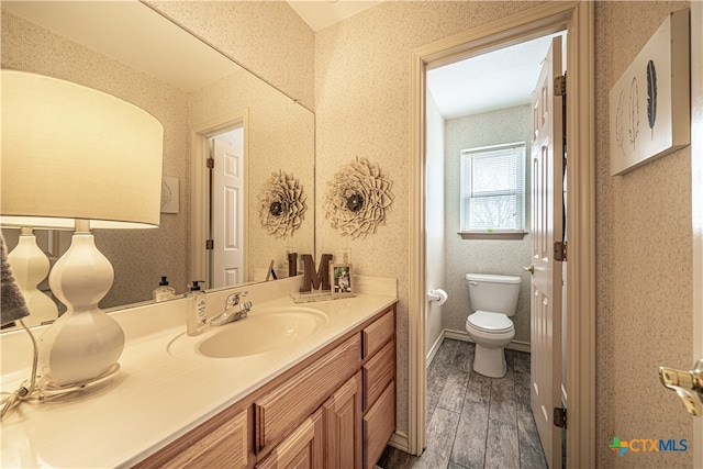 bathroom featuring hardwood / wood-style floors, vanity, and toilet