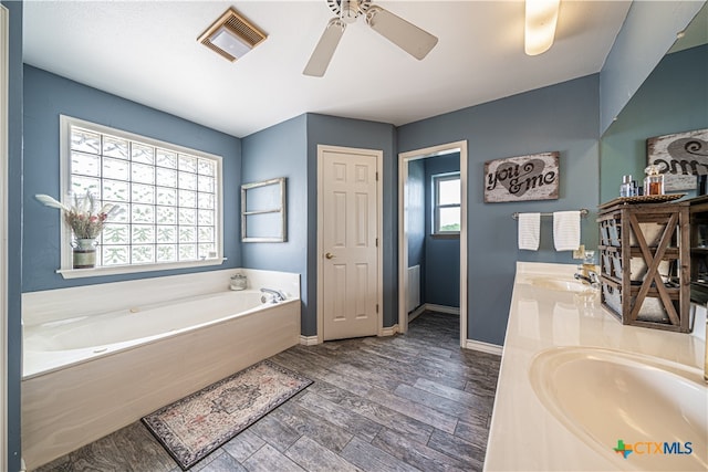 bathroom with a tub to relax in, ceiling fan, vanity, and wood-type flooring